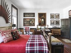 a bedroom with red and black plaid bedding and pictures on the wall above it