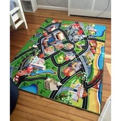 a child's play mat with cars and trucks on it in the middle of a room