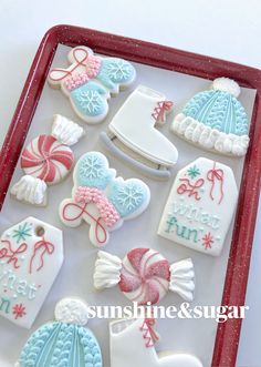 decorated cookies in the shape of hats, mittens and snowflakes on a tray