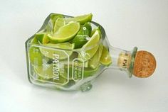 limes in a glass bottle with cork stopper on white table top, ready to be used