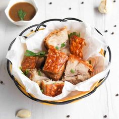 a bowl filled with meat and sauce on top of a table