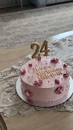 a birthday cake with pink frosting and gold numbers