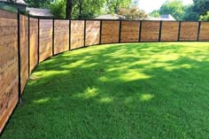 a wooden fence in the middle of a grassy yard