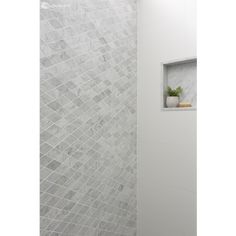 a white shower with a window in the corner and tile on the wall next to it