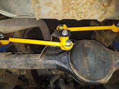 the front end of a vehicle with two yellow springs attached to it's suspensions