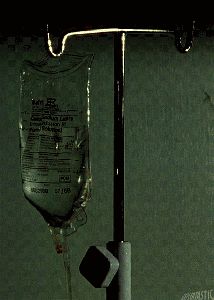 an iv drip is attached to the wall next to a glass tube with water in it