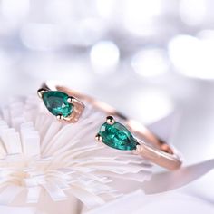 two rings with green stones sitting on top of each other