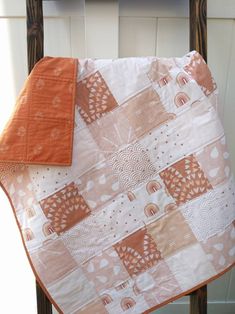 an orange and white quilt on a chair