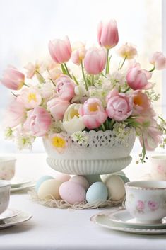 a white vase filled with lots of pink flowers next to some eggs and other dishes