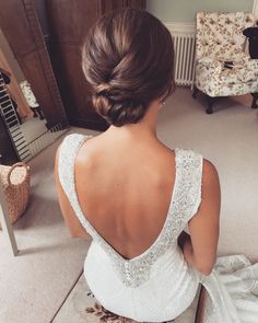 a woman sitting on the floor in front of a mirror wearing a wedding dress and gloves