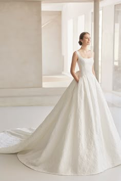 a woman in a white wedding dress posing for the camera