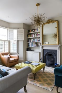 a living room filled with furniture and a fire place in front of a mirror on the wall