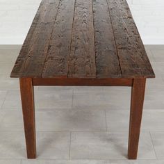 a wooden table sitting on top of a tile floor