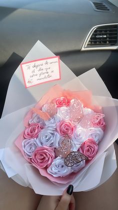 a woman holding a bouquet of roses in her hand with a note attached to it