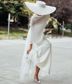 a woman wearing a white hat and dress