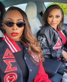 two women sitting in the back seat of a car, one with sunglasses on her head