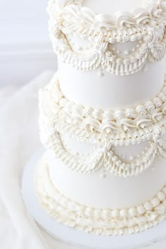 a three tiered white wedding cake on a table