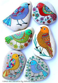 four painted rocks with birds on them