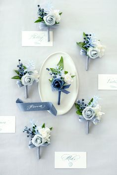 the table is set with blue flowers and place cards for guests to write their names