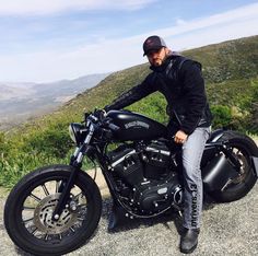 a man sitting on top of a black motorcycle