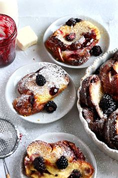 several desserts on white plates with berries and powdered sugar