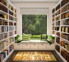 a room filled with lots of books on shelves next to a window sill covered in green and white pillows