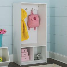 a white bookcase with pink purse and yellow jacket