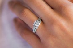 a woman's hand with a diamond ring on it