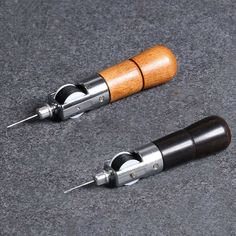 two wood and metal screwdrivers on a gray surface