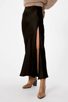 Make a statement in SOPHIE RUE's Manhattan Maxi Skirt - the ultimate all-season wardrobe staple! This sky-high, bias cut skirt features a leg baring, high side slit and a comfy elastic waistband that allows for easy movement. It's the perfect way to turn heads with its timeless maxi length and slight flare at the hem. PRO TIP: Try pairing this skirt with the TRIOMPHE TOP for an easy-to-wear-anywhere fall-ready look! **Sizing notes: This style runs TTS. Model is 5'8" and wearing a size S. MATERIA Black Manhattan, Bias Cut Skirt, Midi Length Skirts, Satin Skirt, Black Skirt, Black Satin, Manhattan, Fabric Care, Maxi Skirt