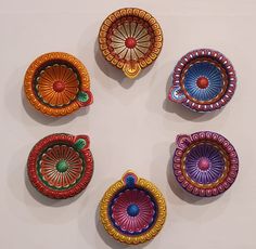 six colorful plates are arranged in a circle on the wall, each with different designs