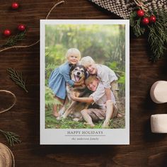 a christmas card with an image of three children and a dog on it, sitting next to marshmallows