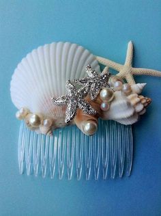 a hair comb with starfish and pearls on it next to a seashell ornament