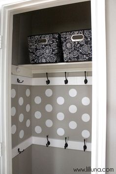 the closet is organized with polka dot wallpaper and storage bins on top of shelves