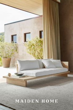 a white couch sitting in front of a window