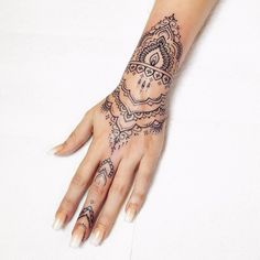 a woman's hand with a henna tattoo on her left arm and wrist