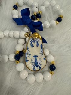 a blue and white beaded necklace with lobsters on it, along with other beads