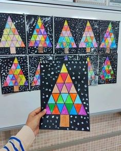 someone is holding up a piece of art that has been made to look like triangles