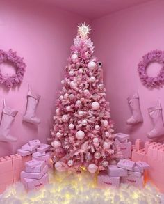 a pink christmas tree surrounded by presents