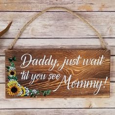 a wooden sign that says daddy just want til you see mommy with sunflowers