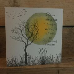 there is a card with a tree and birds in the sky on top of it