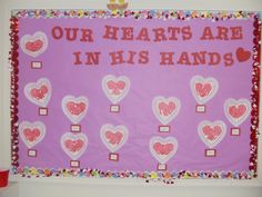 a bulletin board with hearts on it and the words our hearts are in his hands