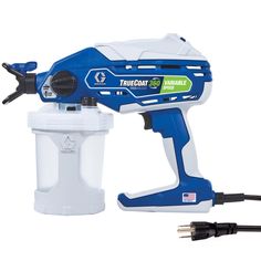 a blue and white paint sprayer sitting next to a plugged in charger