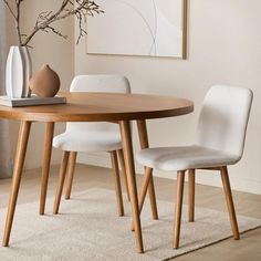 a wooden table with two white chairs next to it