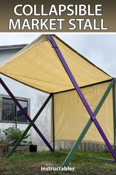 a large yellow and purple tent sitting in the grass