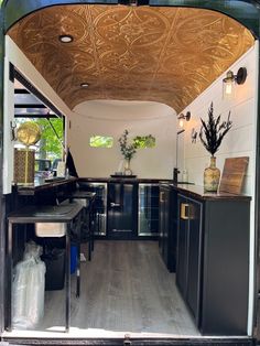 the inside of a camper with wood flooring and black cabinetry is shown