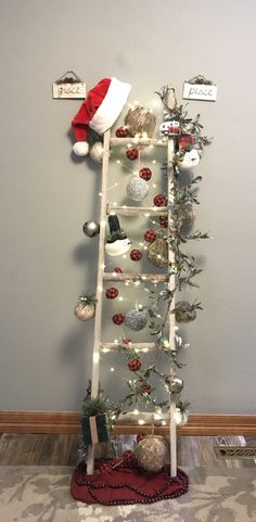 a ladder decorated with christmas ornaments and lights in the corner, along with a santa's hat on top