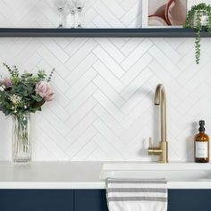 a white kitchen with blue cabinets and gold faucet