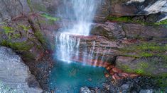 a waterfall is seen from above in this aerial photo, with moss growing on the rocks