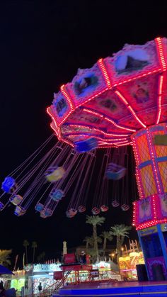 an amusement park at night with lights and rides